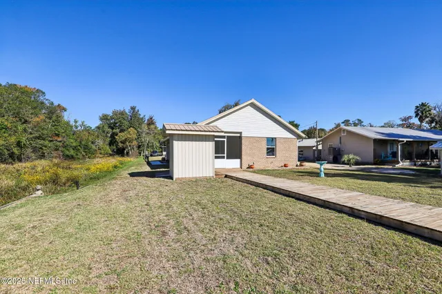 a view of a house with backyard and sitting area