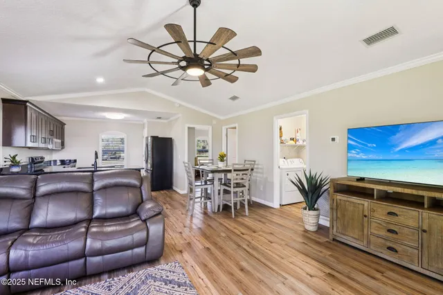 a living room with furniture and a wooden floor