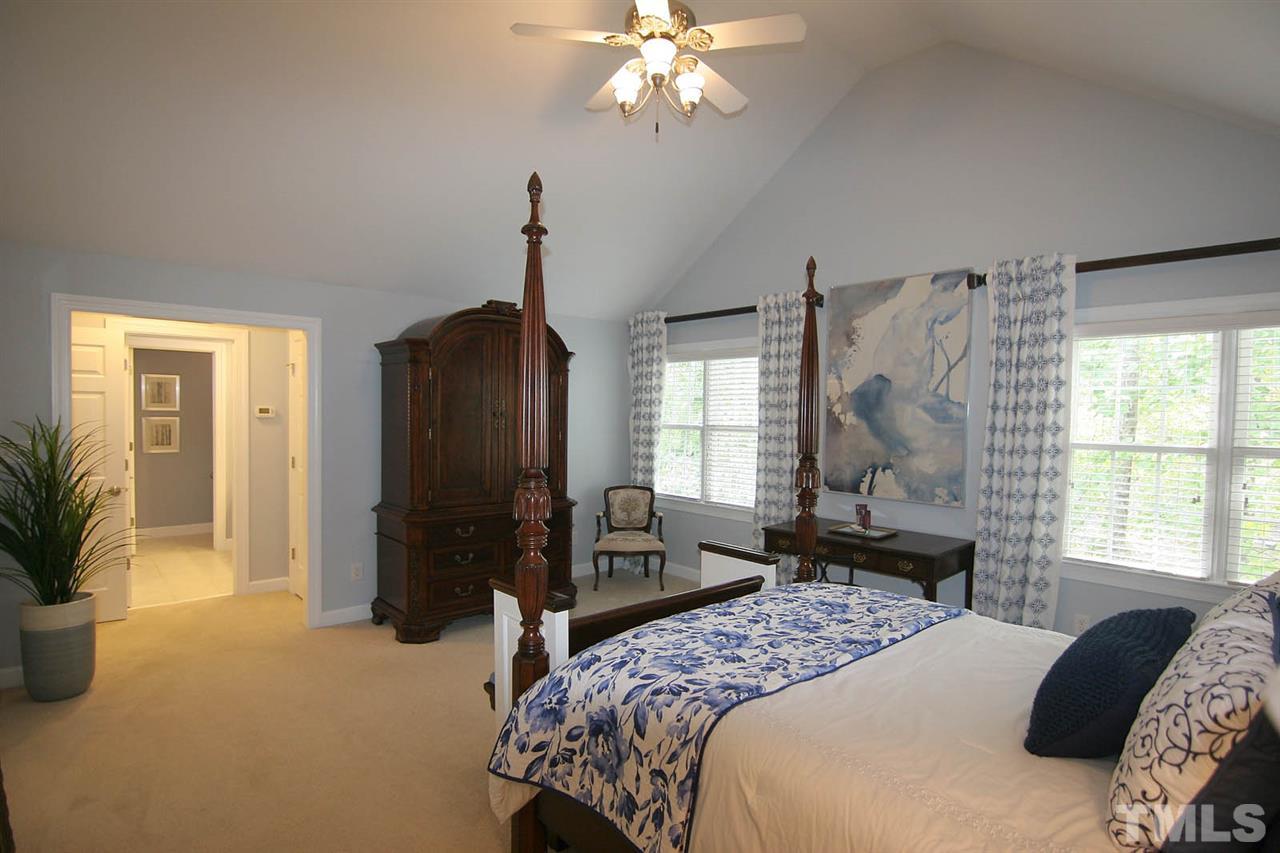 7334 Fontana Ridge Lane Raleigh, NC 27613 - Photo 14 of 24 a bedroom with a bed and a chandelier