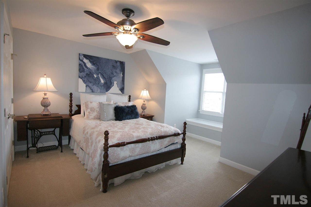 7334 Fontana Ridge Lane Raleigh, NC 27613 - Photo 20 of 24 a bedroom with a bed and a chandelier