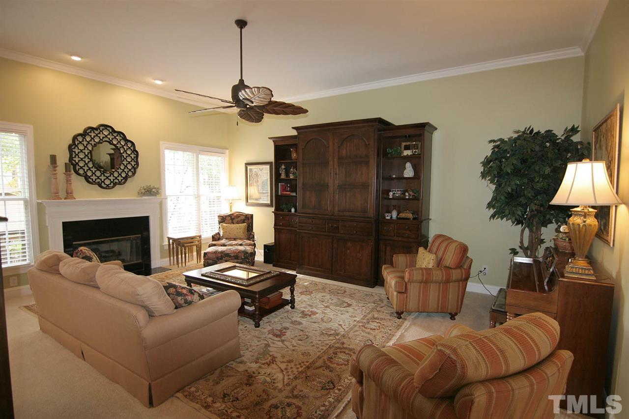 7334 Fontana Ridge Lane Raleigh, NC 27613 - Photo 6 of 24 a living room with furniture a fireplace and a chandelier