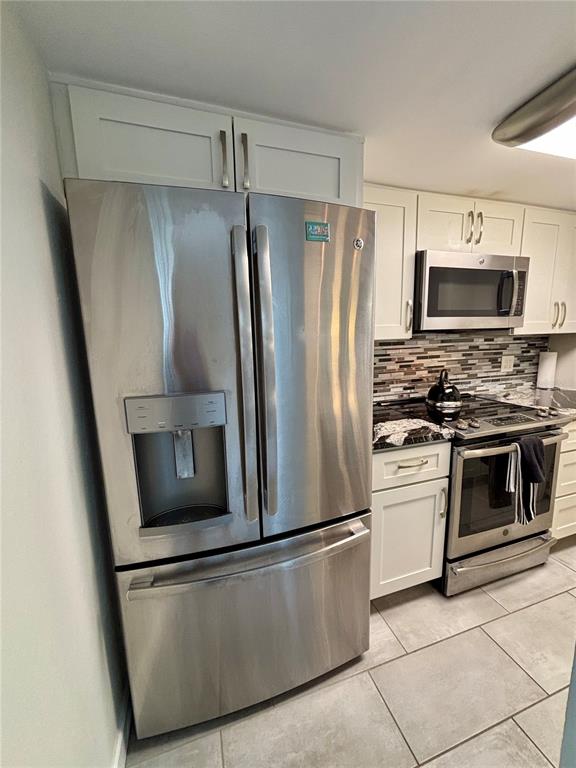 Undisclosed Address Madeira Beach, FL 33708 - Photo 11 of 35 a metallic refrigerator freezer sitting in a kitchen