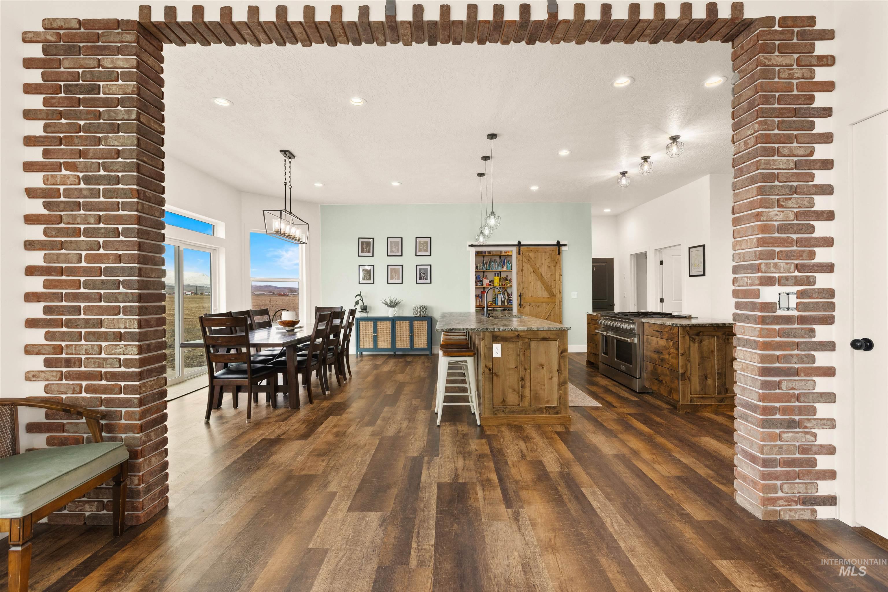5220 West Central Road Emmett, ID 83617 - Photo 15 of 50 Kitchen featuring a barn door, dark wood finished floors, double oven range, a kitchen island, and pendant lighting