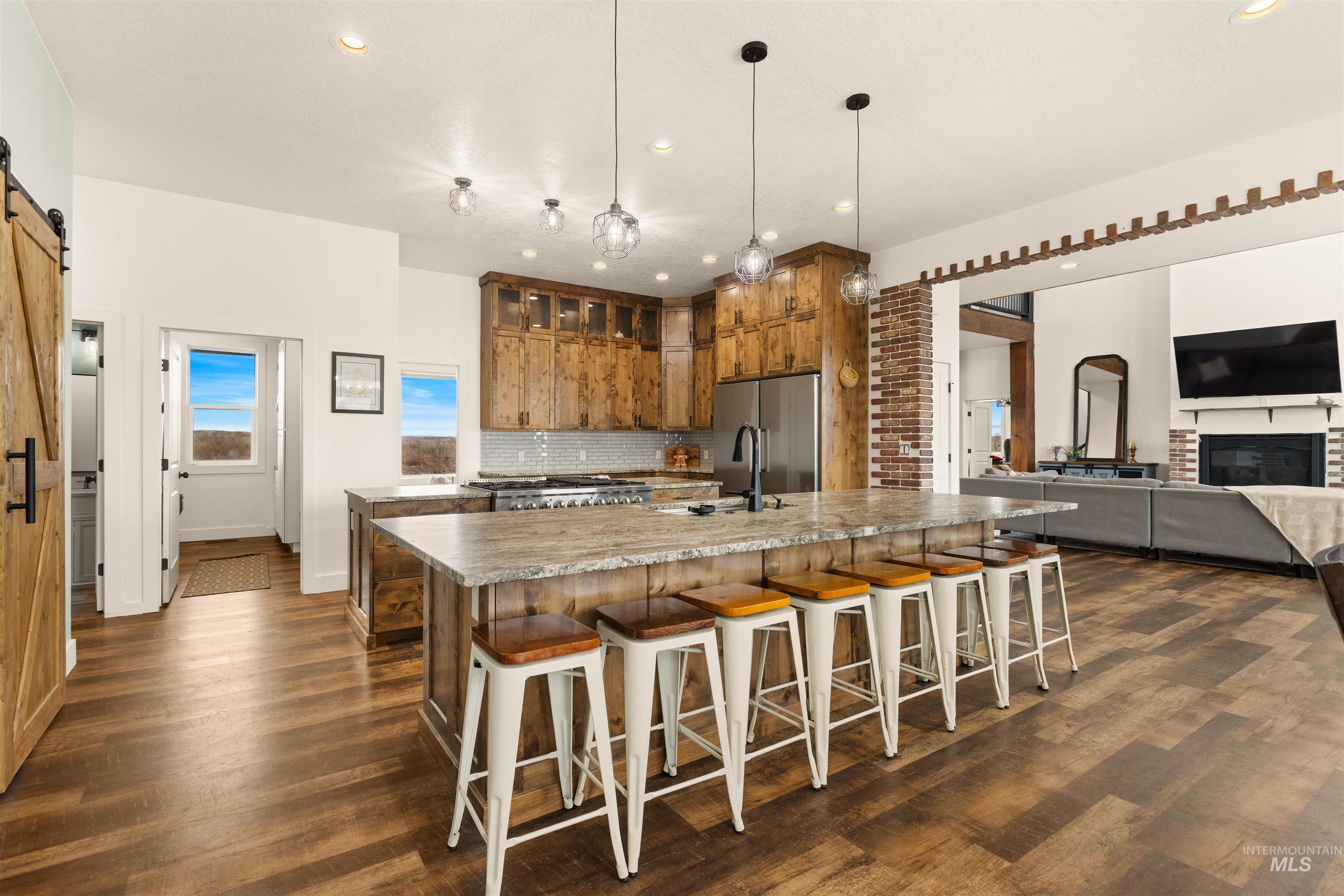 5220 West Central Road Emmett, ID 83617 - Photo 50 of 50 Kitchen featuring a barn door, a large island, open floor plan, a kitchen bar, and wood finish cabinetry