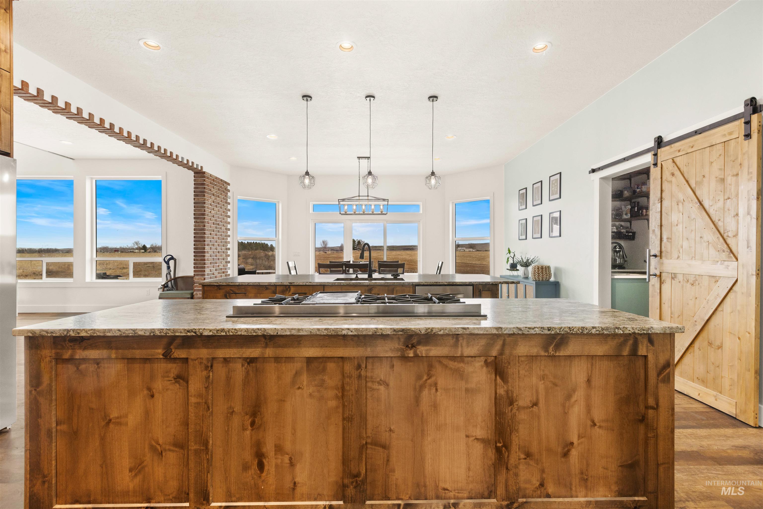 5220 West Central Road Emmett, ID 83617 - Photo 19 of 50 Kitchen featuring a barn door, dark wood-type flooring, pendant lighting, and healthy amount of natural light