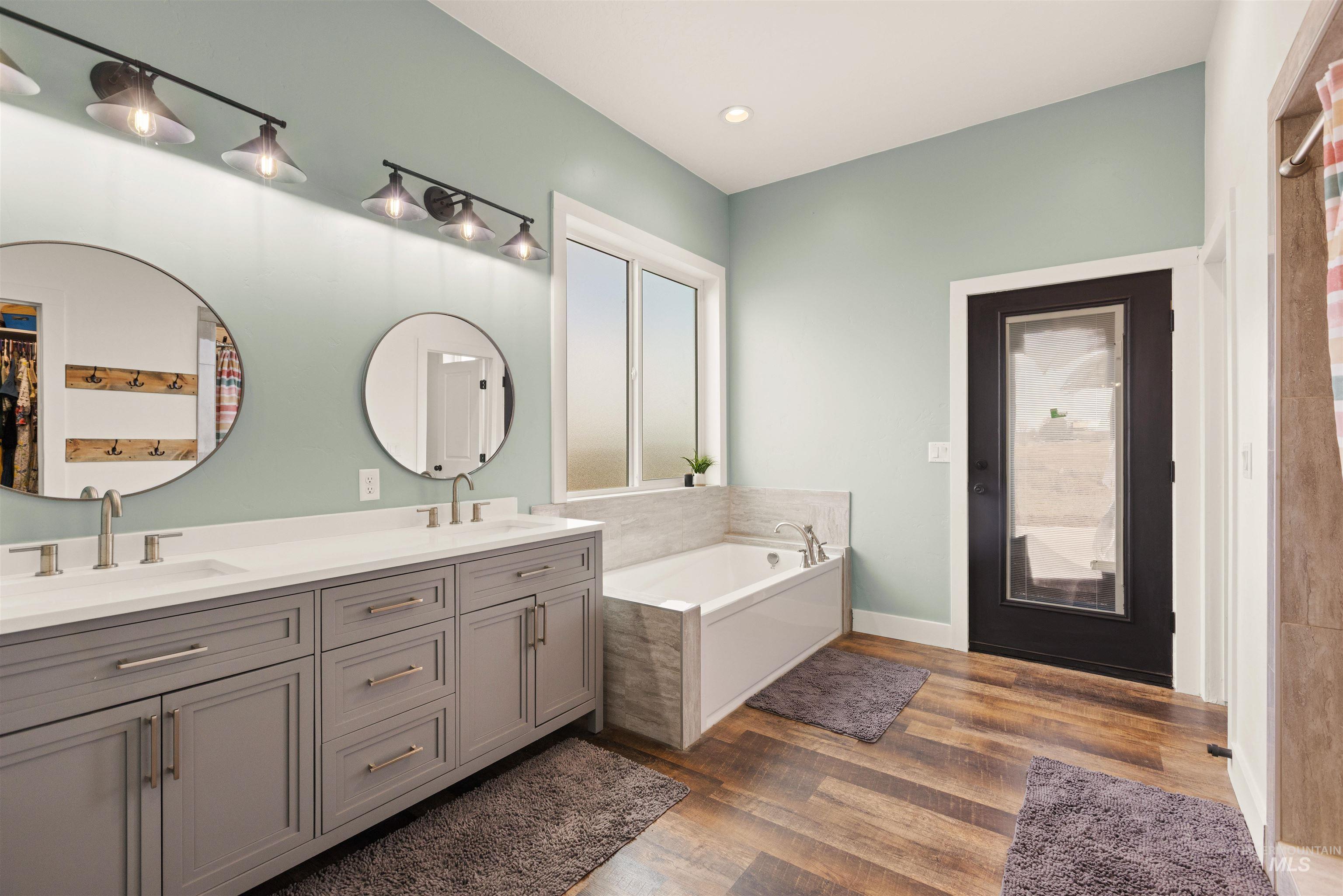 5220 West Central Road Emmett, ID 83617 - Photo 26 of 50 Bathroom featuring a garden tub, double vanity, and dark wood finished floors
