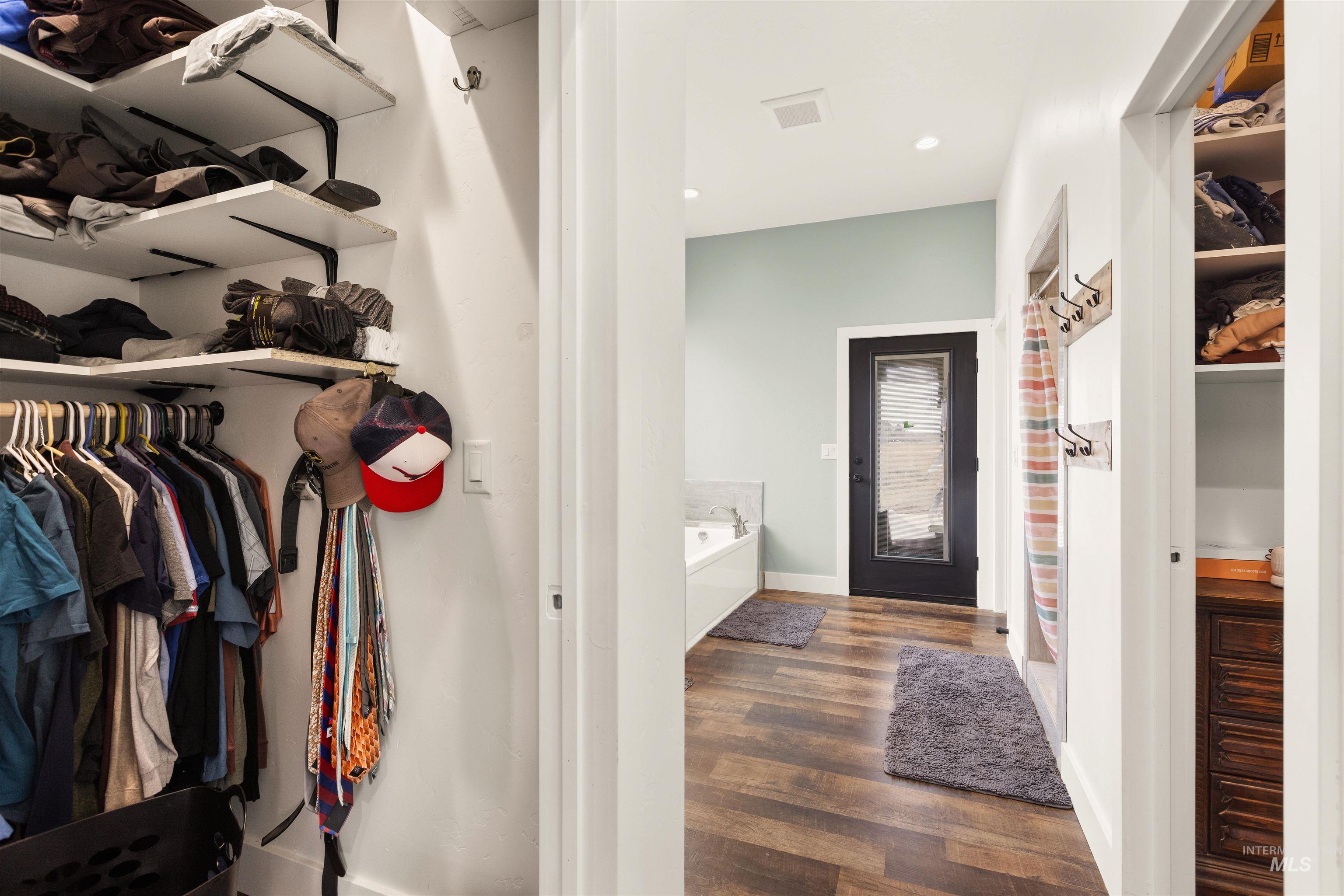 5220 West Central Road Emmett, ID 83617 - Photo 30 of 50 Bathroom featuring a spacious closet, dark wood-style floors, a garden tub, a shower with curtain, and recessed lighting