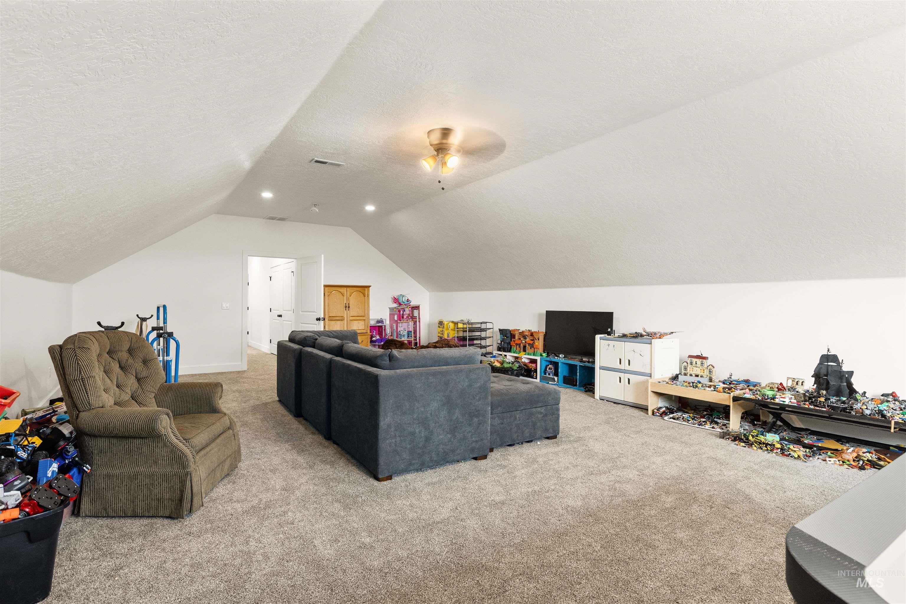 5220 West Central Road Emmett, ID 83617 - Photo 37 of 50 Carpeted living area featuring a textured ceiling and a ceiling fan