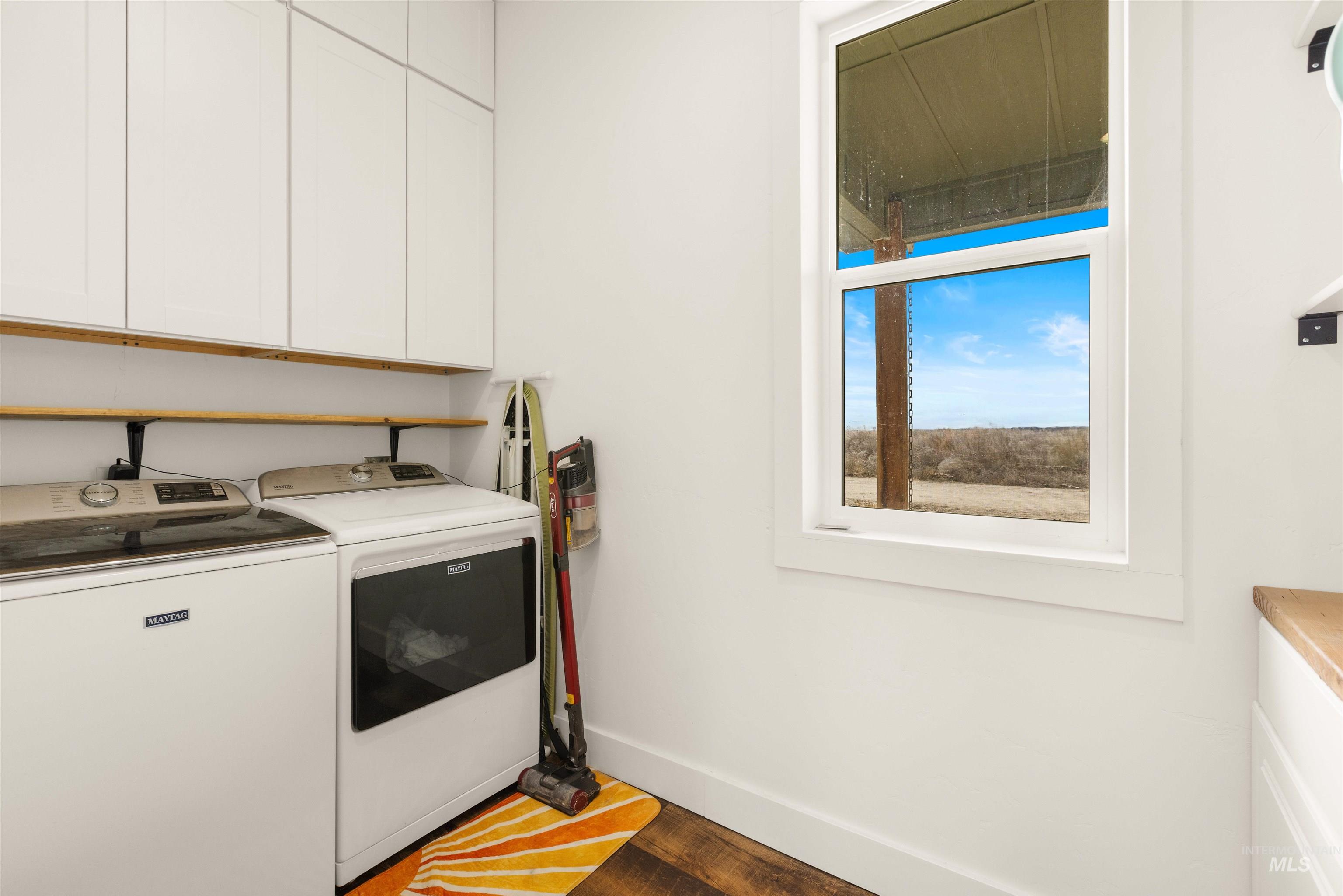 5220 West Central Road Emmett, ID 83617 - Photo 41 of 50 Laundry area with cabinet space, washer and clothes dryer, and wood finished floors