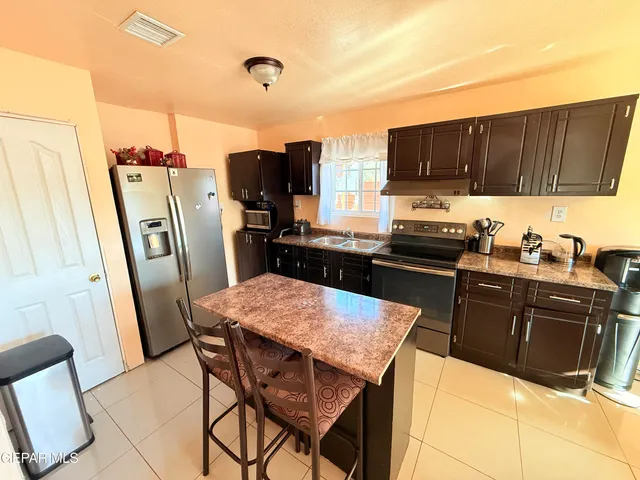 a kitchen with stainless steel appliances granite countertop a refrigerator stove top oven a sink and dishwasher