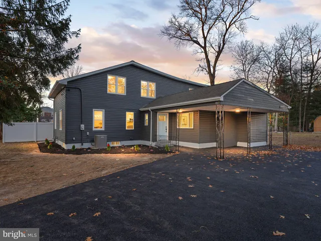 a front view of a house with yard and trees