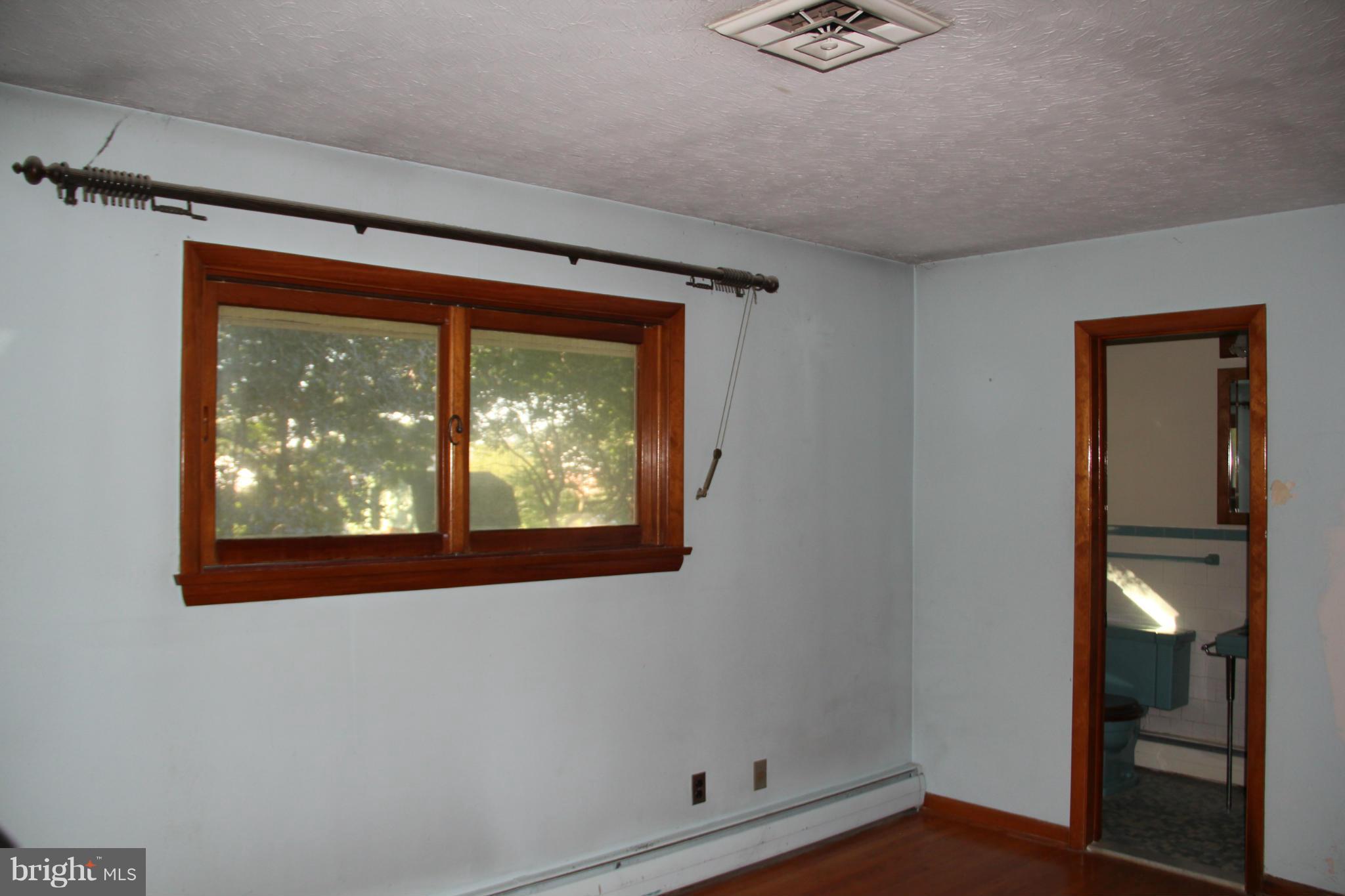 9913 Fox Hill Road Perry Hall, MD 21128 - Photo 13 of 24 a view of an empty room with wooden floor and a window