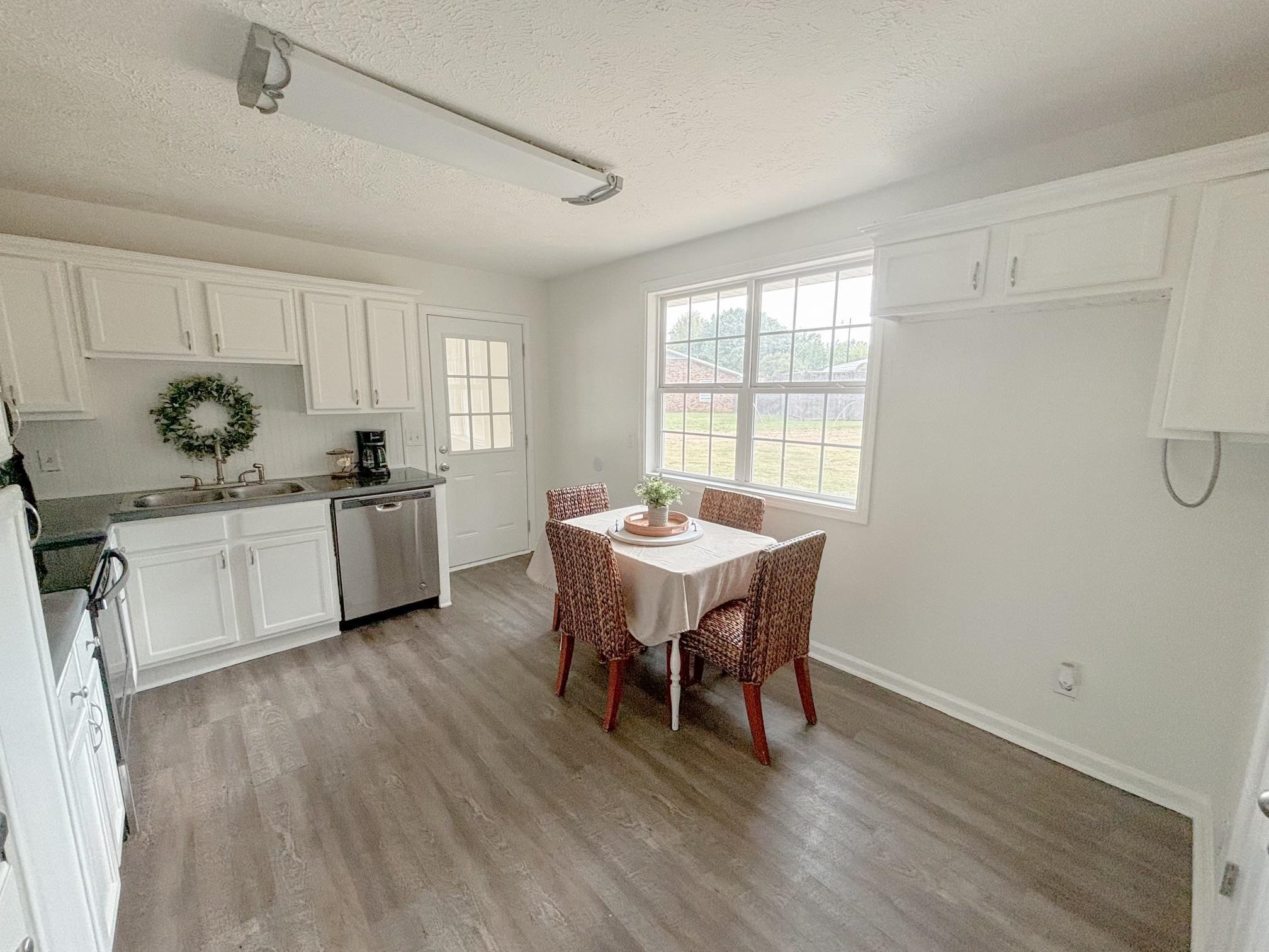 1695 Dawson Road Brighton, TN 38011 - Photo 5 of 13 Kitchen featuring white cabinets, hardwood / wood-style flooring, sink, stainless steel dishwasher, and a textured ceiling