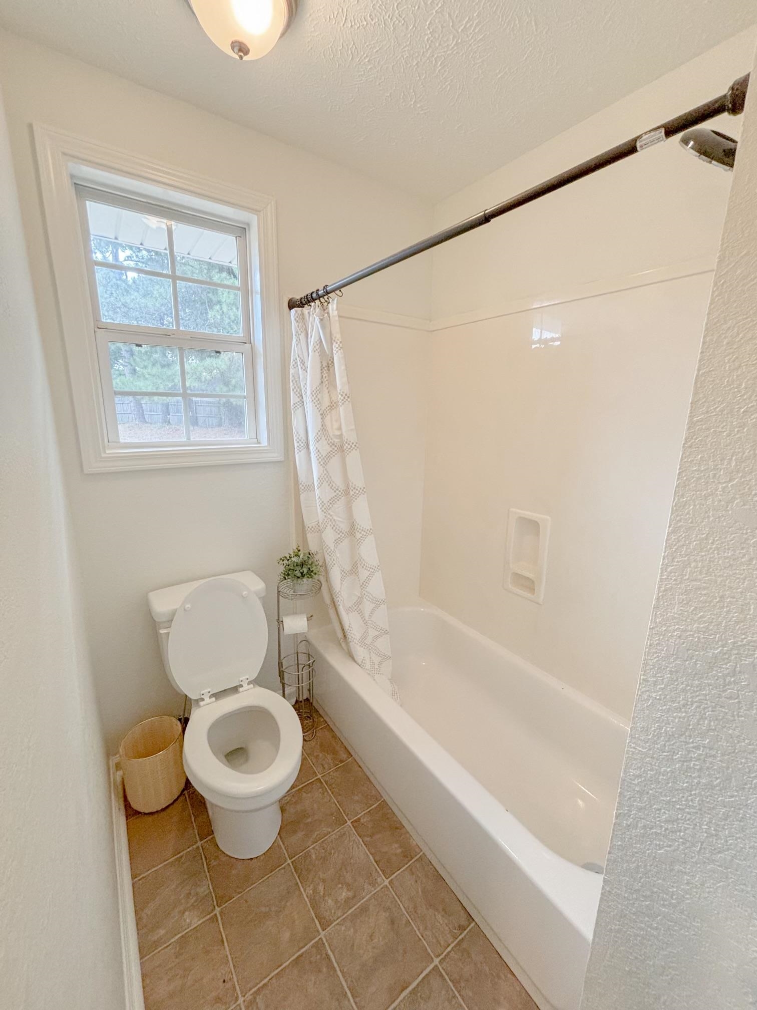 1695 Dawson Road Brighton, TN 38011 - Photo 8 of 13 Bathroom with tile patterned flooring, toilet, a textured ceiling, and shower / bathtub combination with curtain