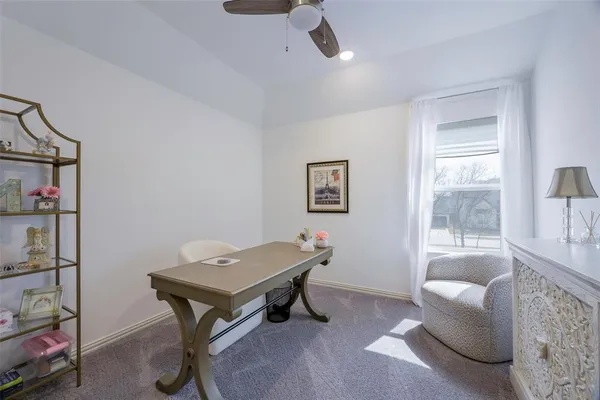 a living room with furniture a ceiling fan and a window