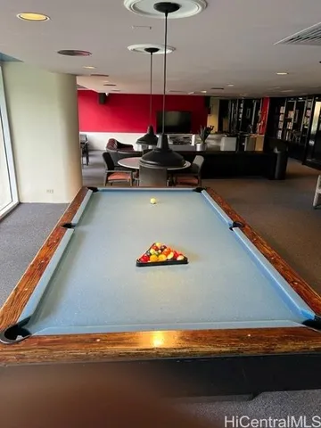 a room with pool table and a rug