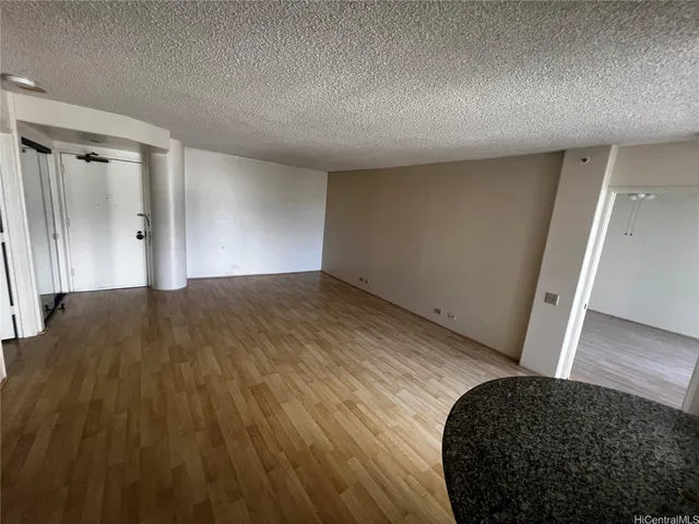 a view of hallway with a closet and wooden floor