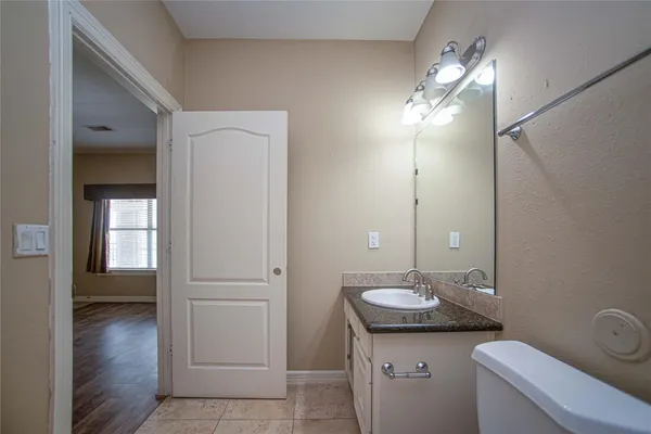 a bathroom with a toilet a sink and mirror