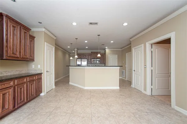 a view of kitchen with kitchen island wooden cabinets and refrigerator
