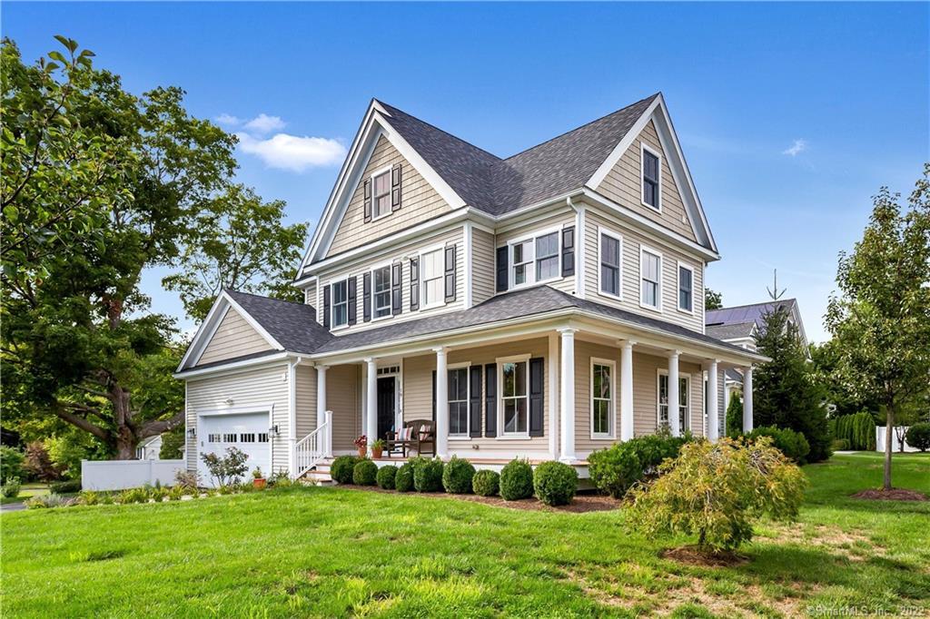 a front view of a house with a yard and trees