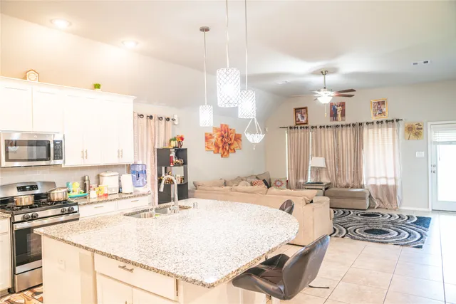 a large kitchen with kitchen island granite countertop a sink and a large window
