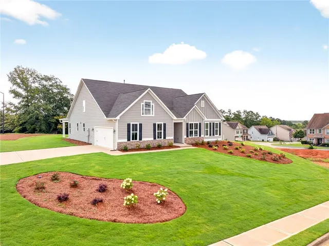 a view of a house with a big yard potted plants and large trees