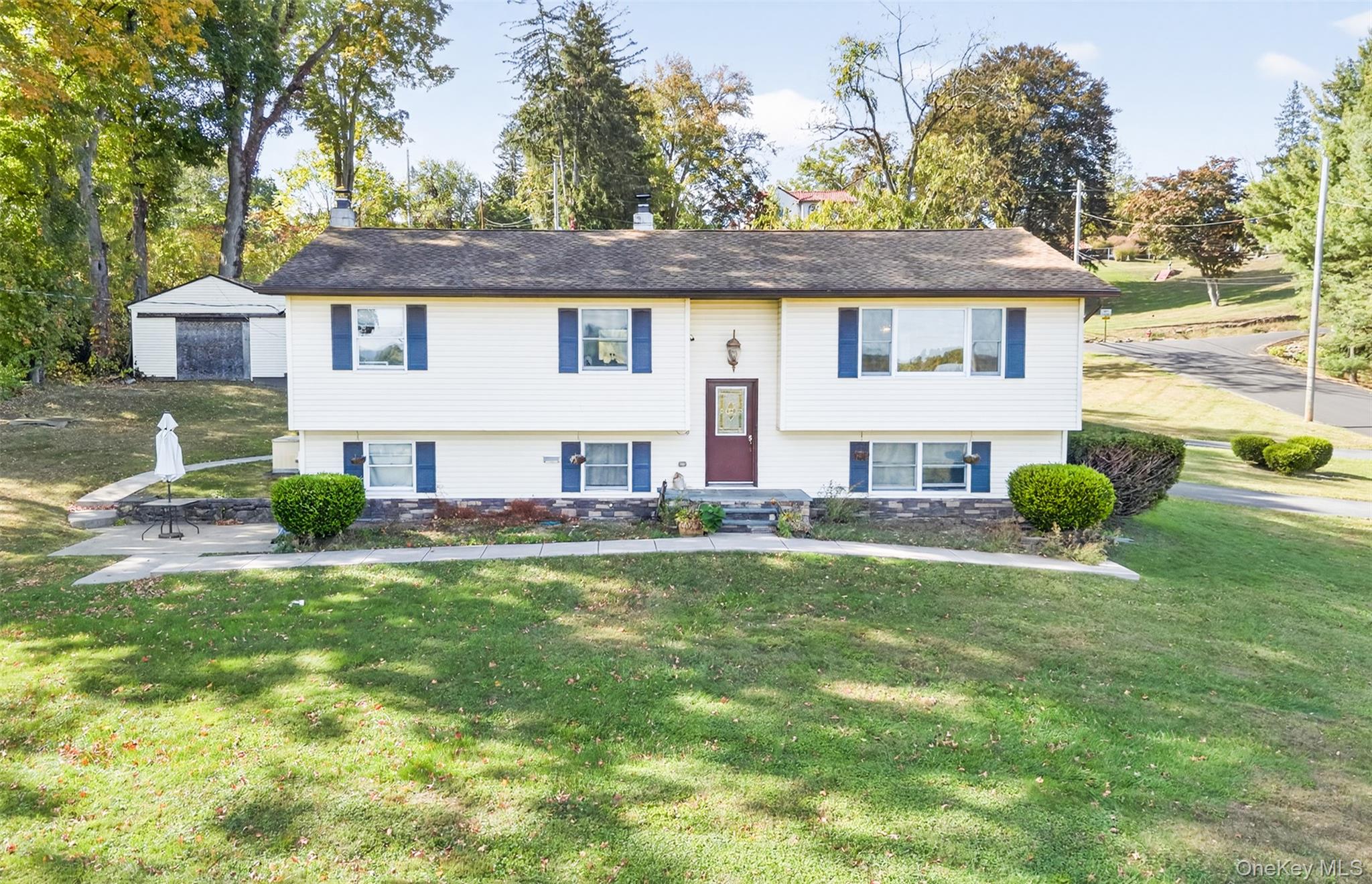 Bi-level home with a chimney and a front lawn