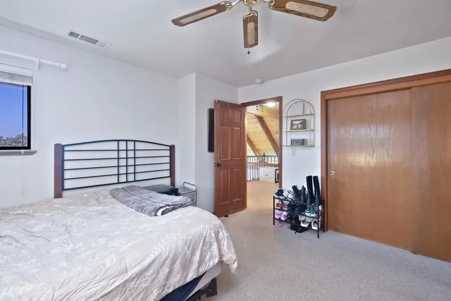 a bedroom with a bed and a large window