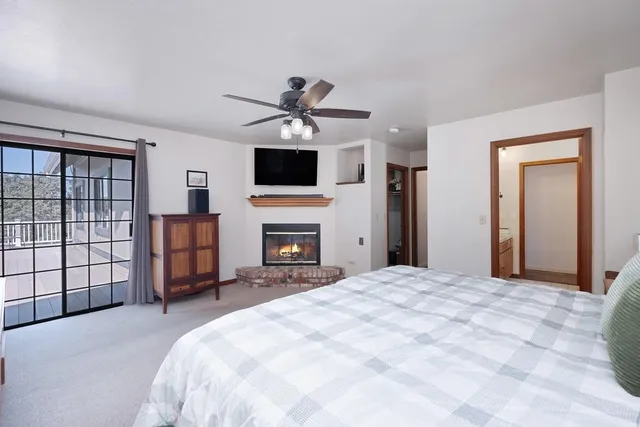 a spacious bedroom with a bed and a flat screen tv