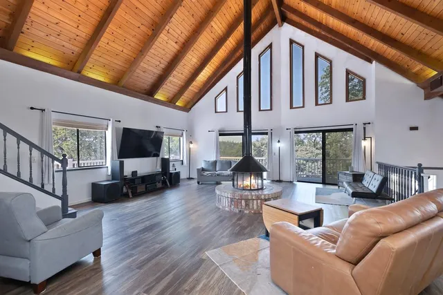 a living room with furniture a flat screen tv and a large window