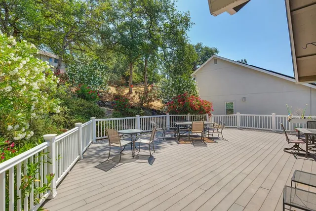 a view of roof deck with chairs and wooden fence