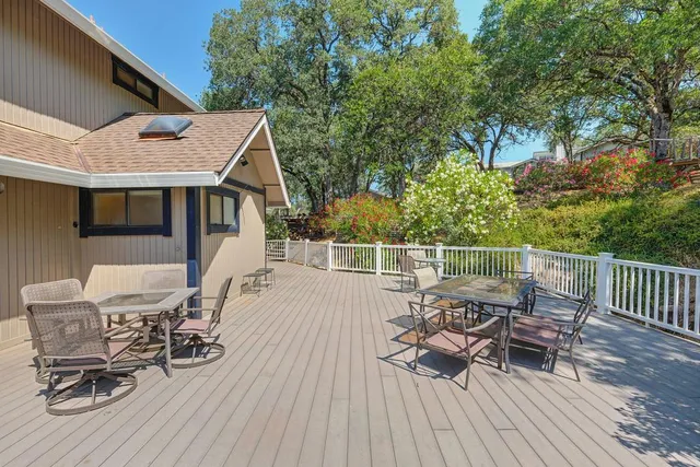 a view of a patio with table and chairs with wooden floor and fence