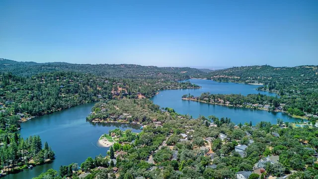 an aerial view of a residential houses with outdoor space and lake view