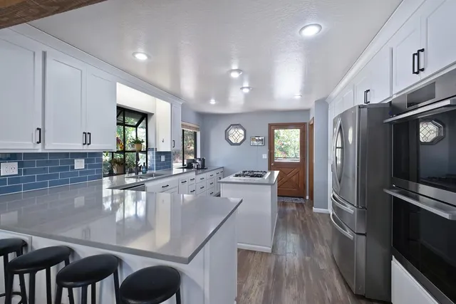 a large kitchen with lots of counter space and stainless steel appliances