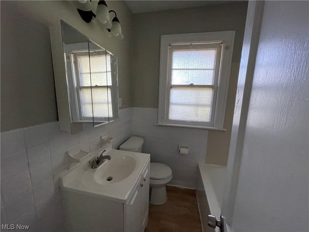 3222 Oak Road Cleveland, OH 44118 - Photo 12 of 13 Bathroom with vanity with extensive cabinet space, tile walls, mirror, and backsplash