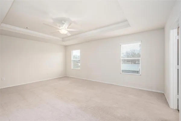 an empty room with a window and a ceiling fan
