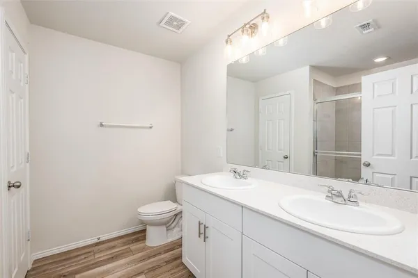 a bathroom with a granite countertop sink toilet a large mirror and shower