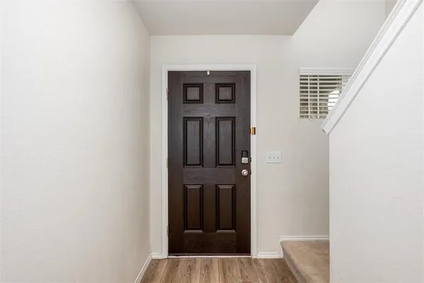 a view of a hallway with wooden floor and entryway