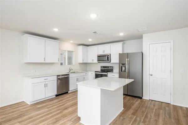 a kitchen with stainless steel appliances a refrigerator stove microwave and cabinets