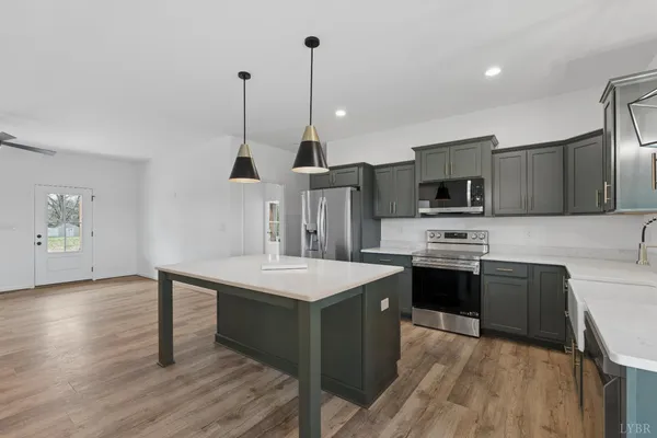 an empty room with wooden floor ceiling fan and windows