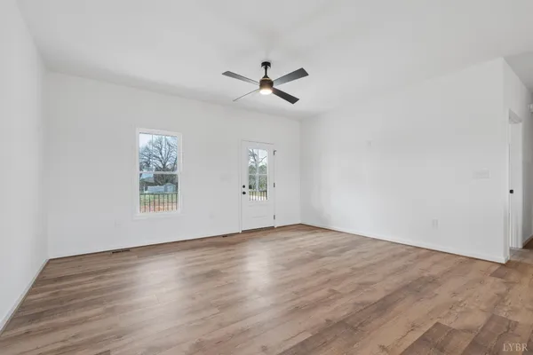 an empty room with a window and a ceiling fan