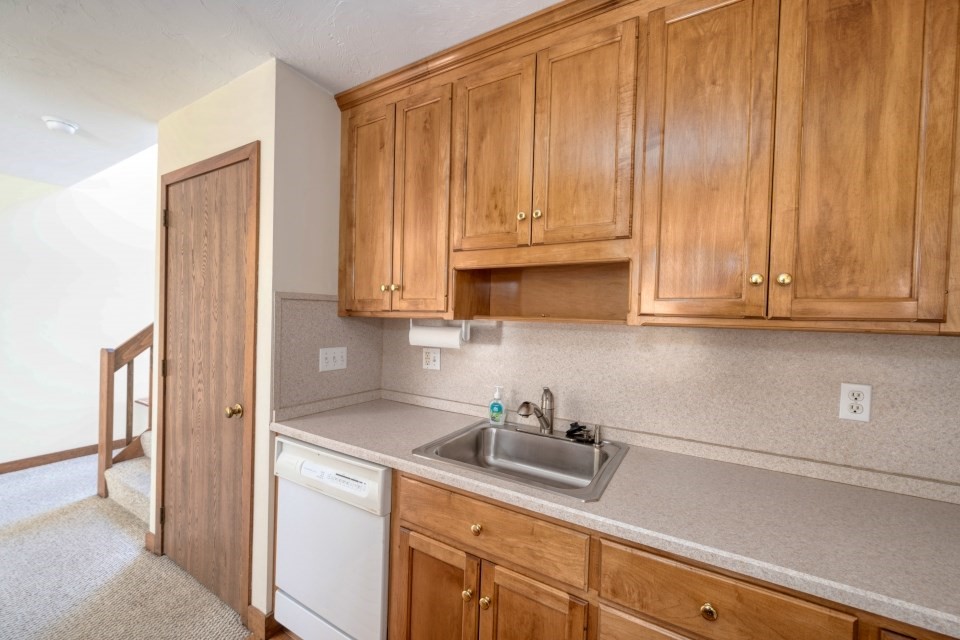 305 Centre Ln., Unit 305 Walpole, MA 02081 - Photo 12 of 23 a kitchen with stainless steel appliances granite countertop white cabinets a sink and dishwasher