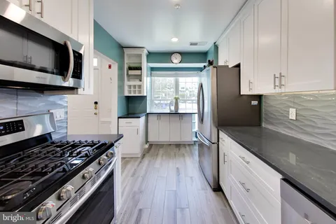 a kitchen with stainless steel appliances granite countertop a stove and a refrigerator