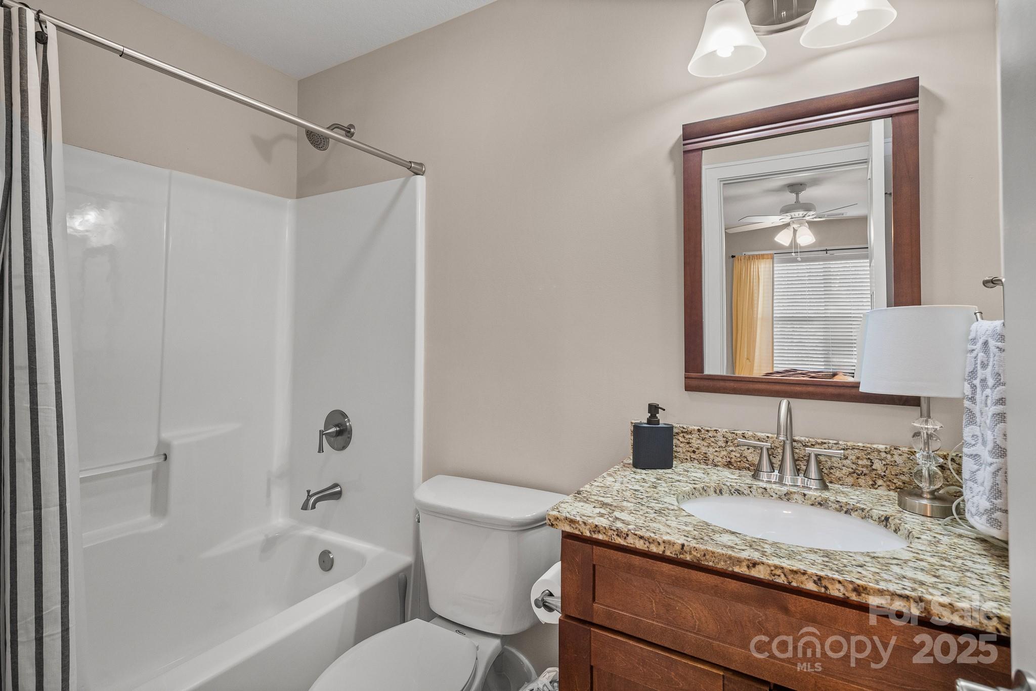 235 Windstone Drive Fletcher, NC 28732 - Photo 30 of 40 a bathroom with a granite countertop sink toilet and shower