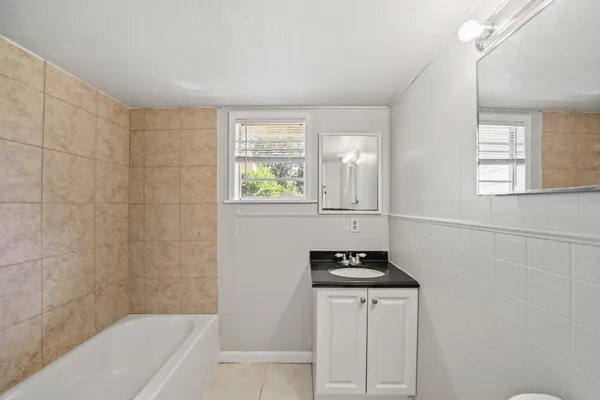 a bathroom with a bathtub a window and a shower