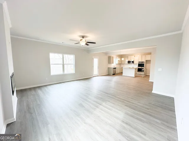 a view of a livingroom with wooden floor and a ceiling fan