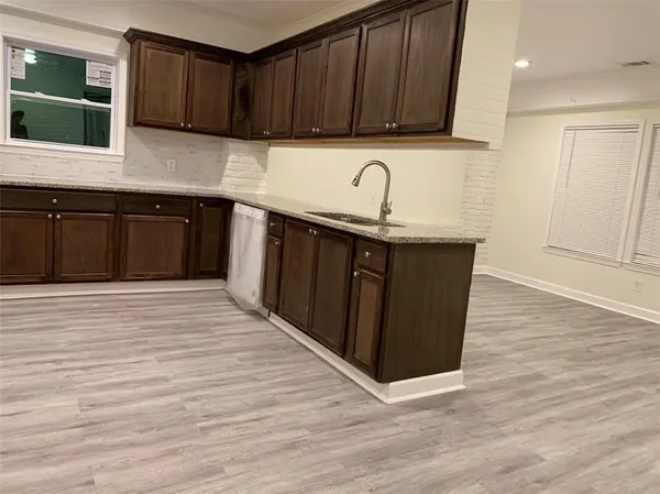 a kitchen with granite countertop wooden cabinets a sink and dishwasher