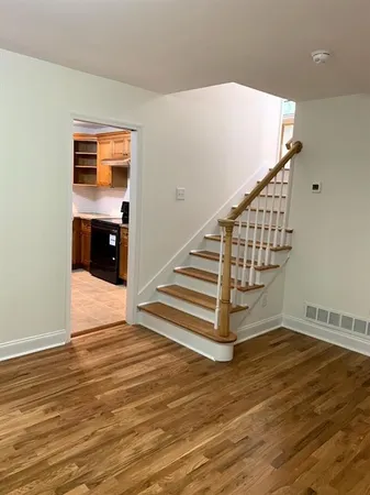 a view of entryway and hall with wooden floor
