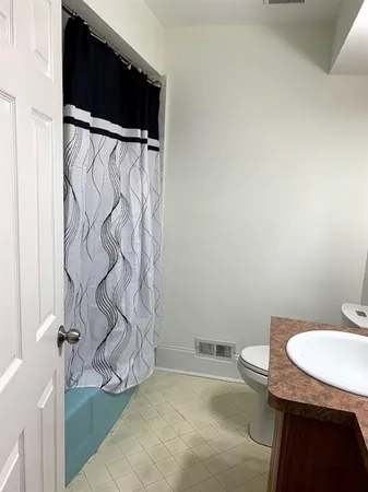 a bathroom with a toilet and a shower curtain