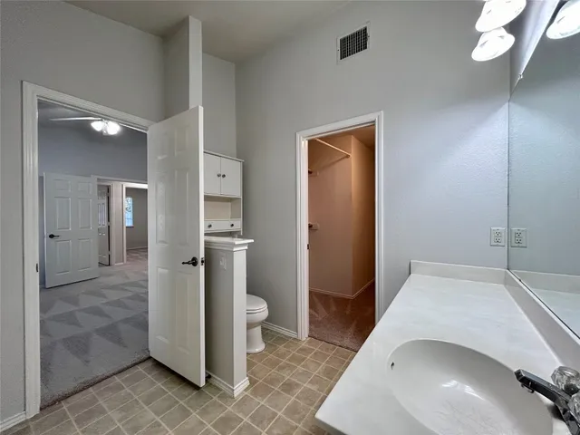 a view of a hallway with bathroom and a sink